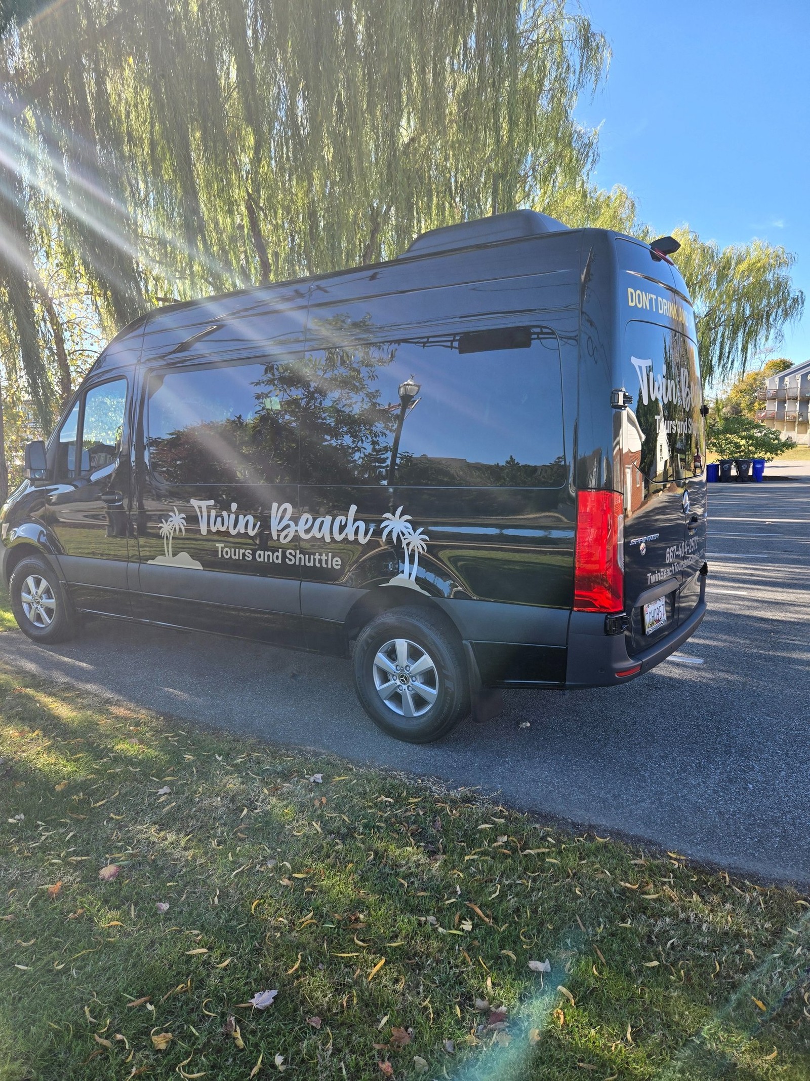 Twin Beach Tours shuttle rear three-quarter view in sunlight