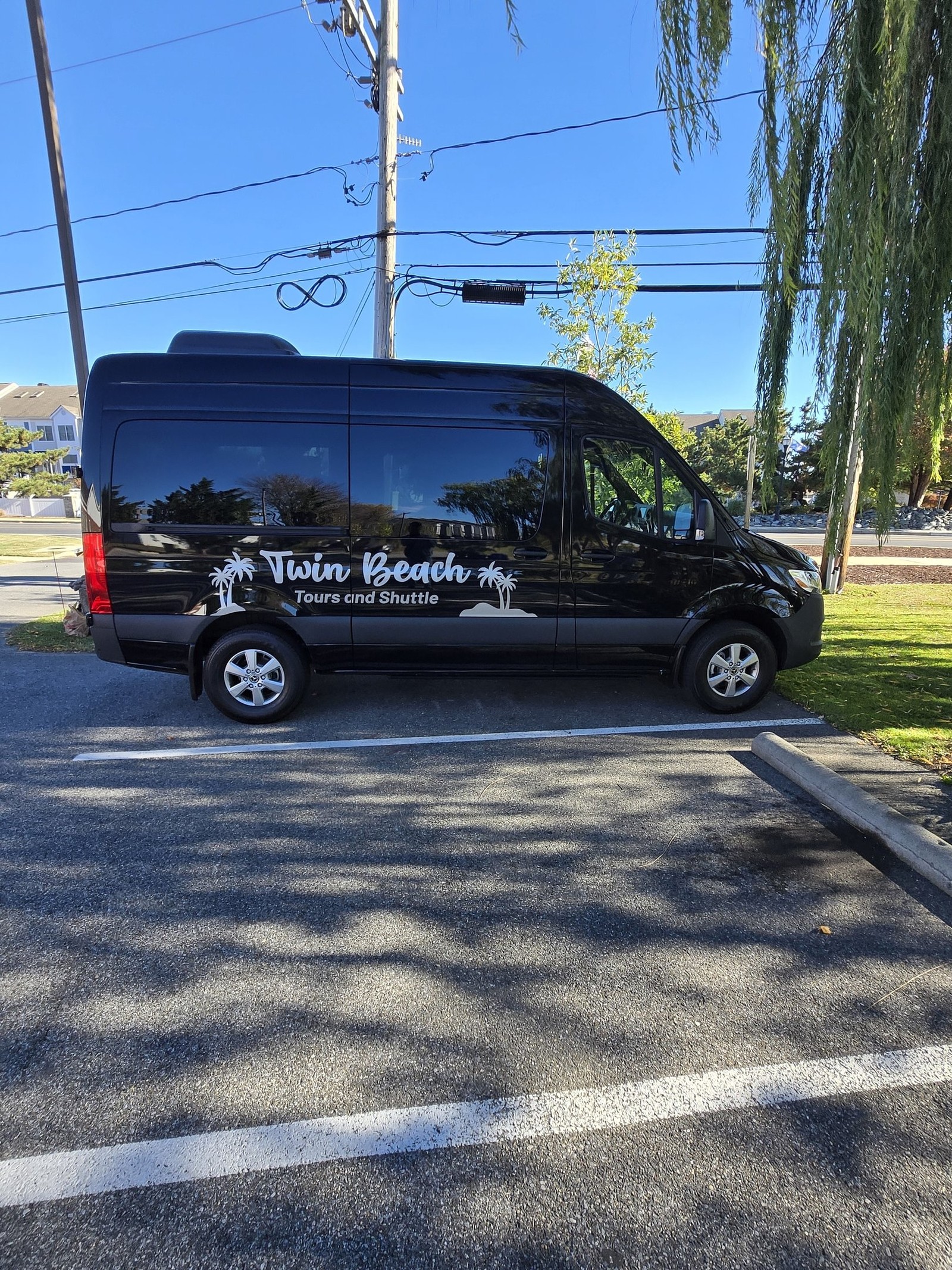 The Twin Beach Tours Mercedes Sprinter shuttle parked on a sunny day